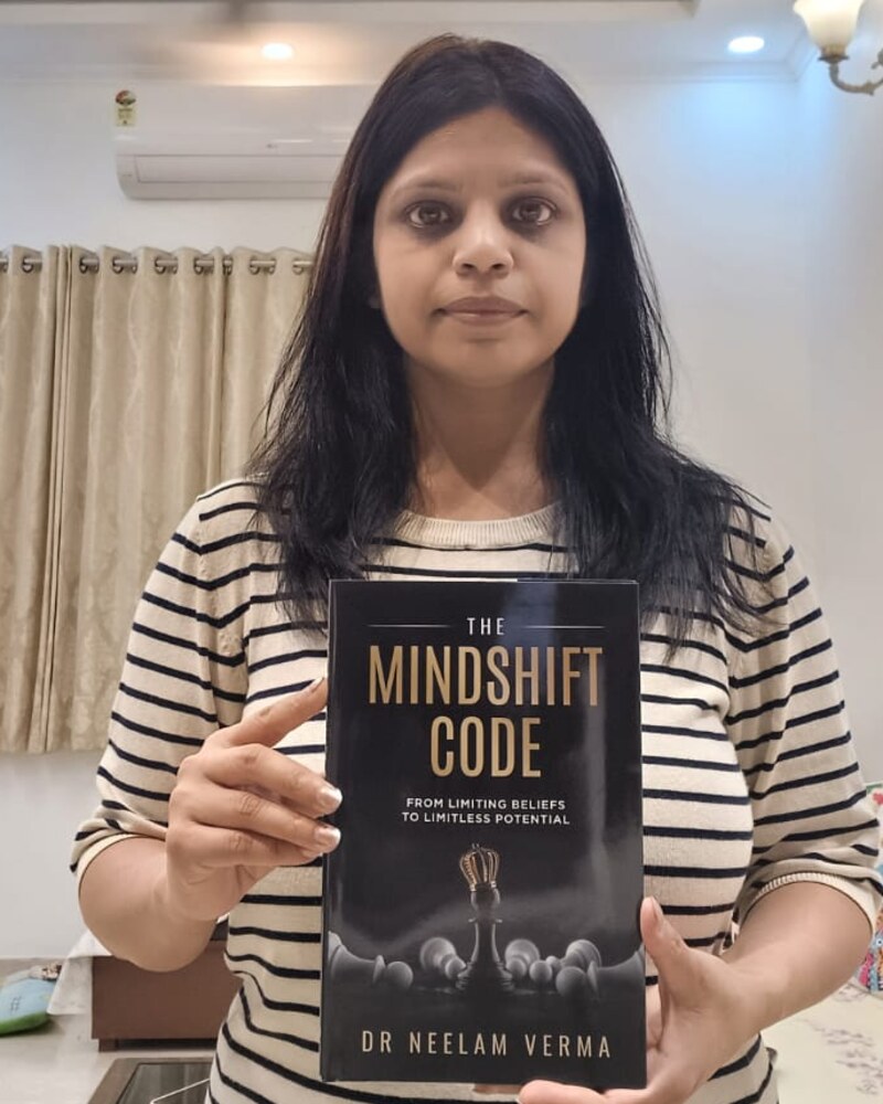Dr Neelam Verma, published author of The Mindshift Code, holding her paperback