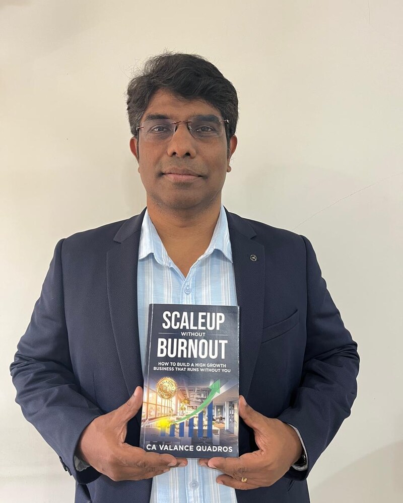 CA Valance Quadros, published author of Scaleup Without Burnout, holding his paperback